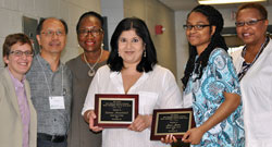 Dianne Ramdeholl, at left and Jaye Jones hold the plaques commemorating their receiving the 2014 AERC Phyllis Cunningham Social Justice Award. The members of the award committee, Lisa Baumgartner, Luis Kong and Doris Flowers stand to Ramdeholl’s left and Vanessa Sheared stands with Jones. AERC 2014 was held on the Harrisburg campus of Penn State University. Photo © Harrisburg State University
