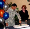 Colonel Bryan Laske, garrison commander at Fort Drum, cuts the cake emblazoned with “A tradition of excellence in education,” the event celebratory theme, as Nikki Shrimpton, dean of undergraduate studies for SUNY Empire, looks on.
