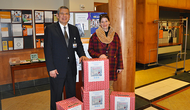 Executive Vice President for Administration Joseph L. Garcia, a retired lieutenant colonel and 28-year veteran of the U.S. Air Force, stands with Librarian Sara Hull in the lobby of 2 Union Ave., Saratoga Springs, N.Y., as cards for the Holidays for Heroes program were collected.