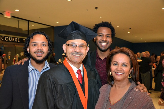 Zekarias Mekonnen surrounded by his wife and two sons at the college Albany commencement event.