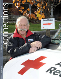 Jim Savitt leaning on a Red Cross vehicle - cover of Connections Spring 2012