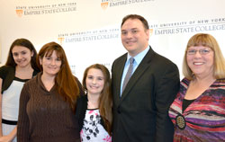 2014 recipient of the Chancellor’s Award for Student Excellence Mark Rider is supported by daughter Claire, far left, wife name, daughter Lauren, and his mother Linda, at his right, at the at the ceremony honoring this year’s winners. Photo/Empire State College