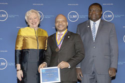 SUNY Chancellor Nancy L. Zimpher stands next to Dwight Anderson '98, '14 who is holding his Chancellor's Award for Student Excellence. Zimpher and Anderson were joined by the college's provost and vice president for academic affairs, Alfred Ntoko, at the 2015 award ceremony for all recipients held in Albany, N.Y./Photo Joe Putrock for SUNY