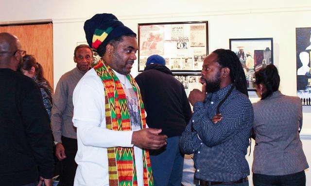 Alumnus Natural Langdon ’17 and Terry Boddie, a member of the college's faculty and a visual artist, talk during the opening reception for 